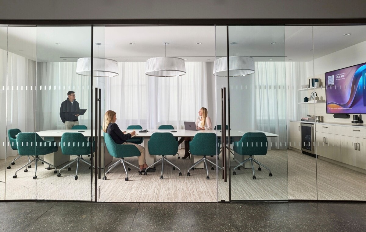 Modern glass-walled conference room with AIS conference table and teal seating