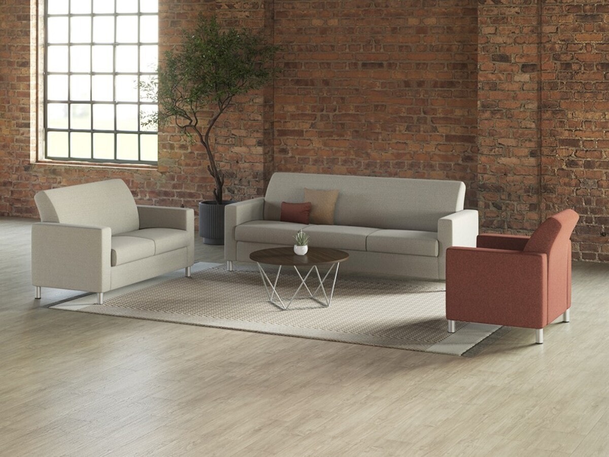 NV lounge seating collection with sofa, chairs and Prisma occasional table in brick loft space